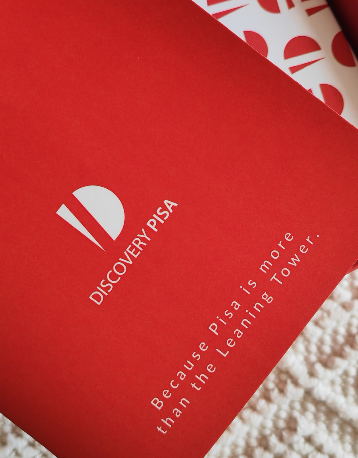 Logo discovery Pisa by Valeria Plasmati stampato su carta, bianco su fondo rosso